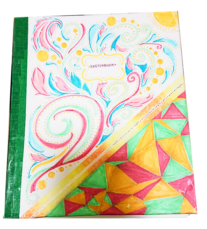 A handmade sketchbook with green, blue, yellow, and red swirls and geometric patterns on the cover